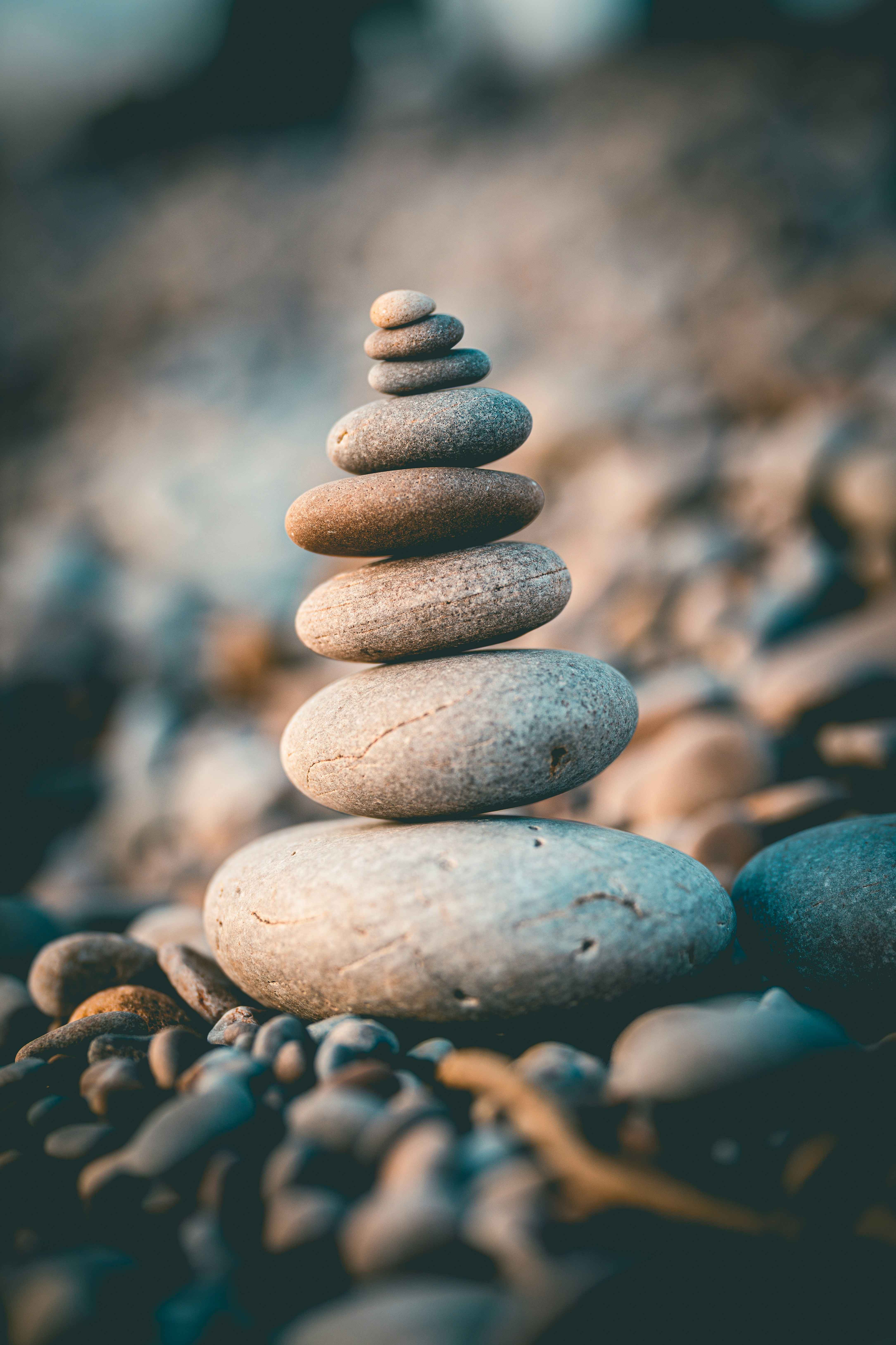 A serene
        image of a stack of smooth stones. Representing peace and tranquility. Photo by Rob Wicks on Unsplash.